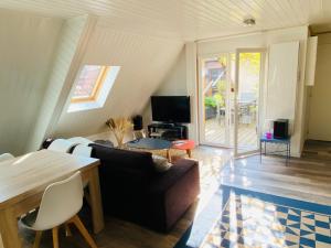 uma sala de estar com um sofá e uma mesa em Joli 2 pièces, climatisé avec terrasse, vue sur les toits, en zone piétonne em Haguenau