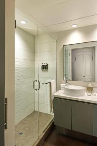 W łazience znajduje się umywalka i przeszklony prysznic. w obiekcie Hotel Colonnade Coral Gables, Autograph Collection w Miami