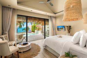 a bedroom with a bed and a view of the ocean at ODYSSEY - Luxury Beachfront Mansion - in Koh Samui