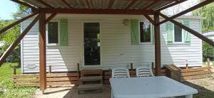 a screened in porch of a house with a table and chairs at Camping LE Moulin in La Motte-Chalançon