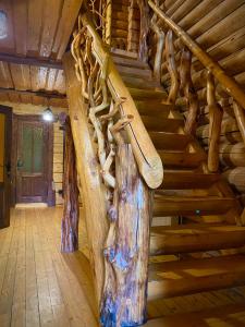 a staircase in a log cabin with wooden steps at Гостинний двір in Oryavchyk