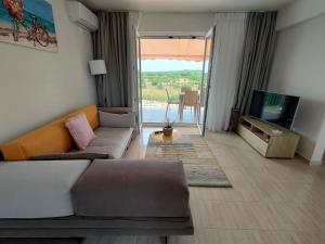 a living room with a couch and a tv at Iridia Resort Villas in Foiníki