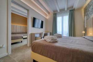 a hotel room with a bed and a television at Hotel Palazzo del Garda & Spa in Desenzano del Garda