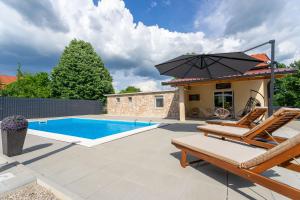 a patio with chairs and an umbrella next to a swimming pool at Kuca za odmor Sliskovic 
