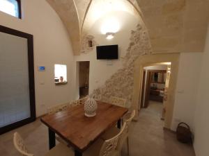 comedor con mesa de madera y pared de piedra en Antica Dimora "Lu suli, Lu mari, Lu jentu", en Monacizzo