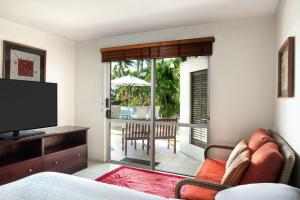 a room with a bed and a television and a patio at Sheraton Denarau Villas in Denarau