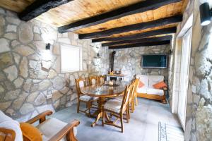 a stone walled dining room with a table and chairs at Kuca za odmor Sliskovic 