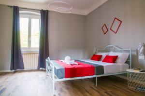 1 dormitorio con cama blanca y almohadas rojas en DREAM STATION 5TERRE, en La Spezia