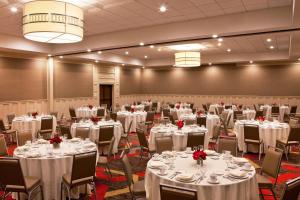 un salón de banquetes con mesas y sillas blancas en Four Points By Sheraton - Saginaw, en Saginaw
