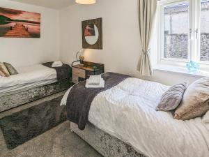 a bedroom with two beds and a window at The Coach House - Uk38044 in Beetham