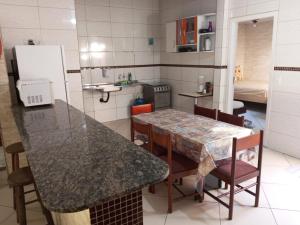 une cuisine avec un comptoir, une table et des chaises dans l'établissement Casa Temporada, à Serra