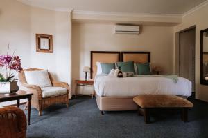 a bedroom with a large bed and a chair at Floreal House in Cape Town +8 photos
