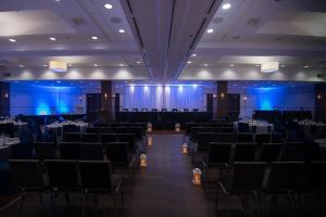 um salão de banquetes com mesas, cadeiras e luzes azuis em Four Points by Sheraton Winnipeg South em Winnipeg