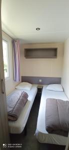 a room with two beds and a window at Camping LE Moulin in La Motte-Chalançon