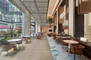 a lobby with tables and chairs in a building at Courtyard by Marriott Wenzhou Yueqing in Yueqing