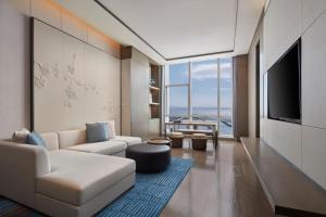 a living room with a couch and a tv at Courtyard by Marriott Wenzhou Yueqing in Yueqing