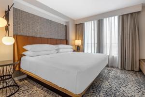 a large white bed in a hotel room at Sheraton Suites Old Town Alexandria in Alexandria +55 photos