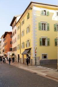 um grupo de pessoas andando por uma rua ao lado de edifícios em YUGOGO MAZZINI 41 - BILOCALE Trento Centro em Trento