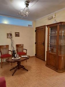 - un salon avec une table, des chaises et un lustre dans l'établissement Casa del Centro Storico, à Corfou