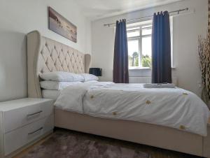 a bedroom with a large bed and a window at The Saxon Rooms in Barking