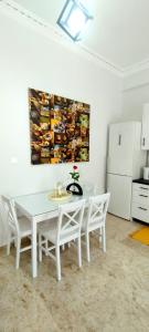 a white table and chairs in a kitchen with a painting on the wall at Didis Place Nafplio in Nafplio