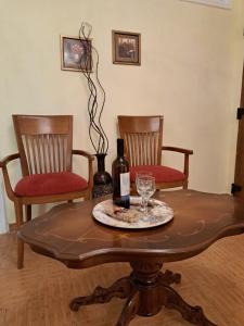 Una botella de vino sentada en una mesa con dos sillas en Casa del Centro Storico en Corfú