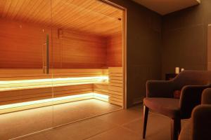 a sauna with a bench and a chair in a room at Hotel Palazzo del Garda & Spa in Desenzano del Garda