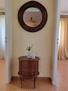 un miroir rond sur un mur au-dessus d'une table en bois dans l'établissement Casa del Centro Storico, à Corfou
