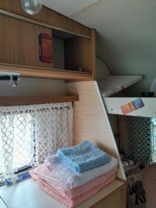 einen Haufen Handtücher, die auf einem Regal in einem Zimmer liegen in der Unterkunft Kapitalac in Banatska Palanka
