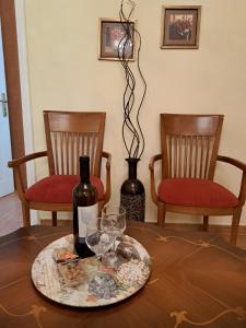 Una botella de vino sentada en una mesa con dos sillas en Casa del Centro Storico en Corfú