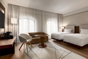Habitación grande con 2 camas y sofá en AC Hotel by Marriott Wroclaw en Breslavia