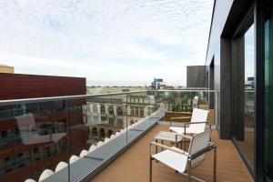 balkon z krzesłami i widokiem na budynek w obiekcie AC Hotel by Marriott Wroclaw we Wrocławiu