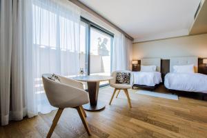 a hotel room with a bed and a table and chairs at AC Hotel by Marriott Wroclaw in Wrocław