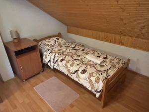 a small bedroom with a bed and a night stand at Apartman MAURO in Rakovica
