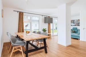 a dining room and living room with a wooden table and chairs at Zur Oie 27b in Bresewitz