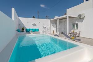 a swimming pool in front of a house at Kapetan Giannis Suite in Adamantas