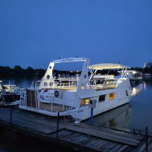a white boat is docked at a dock at Free Room Boat Apartment in Belgrade