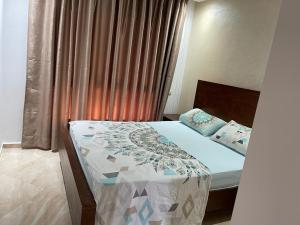 - une chambre avec un lit et une fenêtre avec des rideaux dans l'établissement sidi rahal ramoflores, à Sidi Rahal