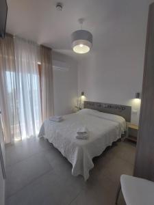 a white bedroom with a bed with a white blanket at Hotel San Domingo in Lido di Camaiore