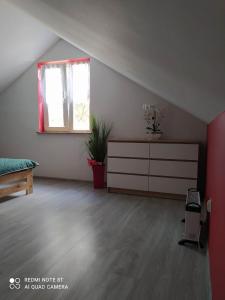 a room with a bed and a dresser and a window at Całoroczny domek letniskowy nad zalewem Chańcza in Życiny