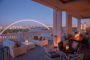 einen Balkon mit Sofas, Tischen und einer Brücke in der Unterkunft The St. Regis Astana in Astana