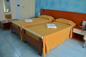 2 Betten in einem Hotelzimmer mit Handtüchern darauf in der Unterkunft Megaron Hotel in Pozzallo