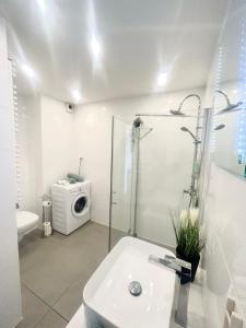 a bathroom with a sink and a washing machine at Downtown Apartments Family&Friends in Rzeszów +36 photos