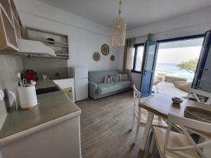 a kitchen and living room with a view of the ocean at Lareroom 4 Σπίτι μπροστά στην παραλία με μικρή πισίνα in Kithnos