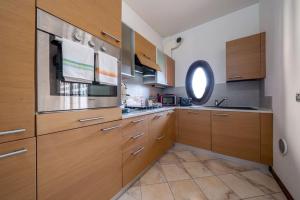 a large kitchen with wooden cabinets and a window at [10min dalla Ghirlandina] Love and relax in Modena in Modena