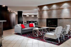 a living room with a couch and chairs and a fireplace at Four Points by Sheraton Mississauga Meadowvale in Mississauga