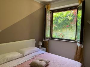 um quarto com uma cama e uma grande janela em Nonna Lella - Appartamento con parcheggio privato em Montepulciano