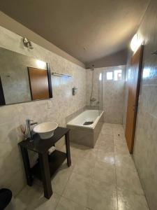 ein Badezimmer mit einer Badewanne, einem Waschbecken und einer Badewanne in der Unterkunft POSADA DEL CENTRO in Villa General Belgrano