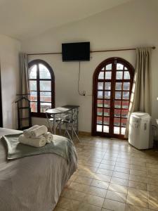 a bedroom with a bed and a table with chairs at POSADA DEL CENTRO in Villa General Belgrano