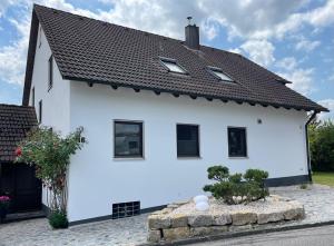 une maison blanche avec un toit noir dans l'établissement Apartment am Stadtpark, à Neumarkt in der Oberpfalz